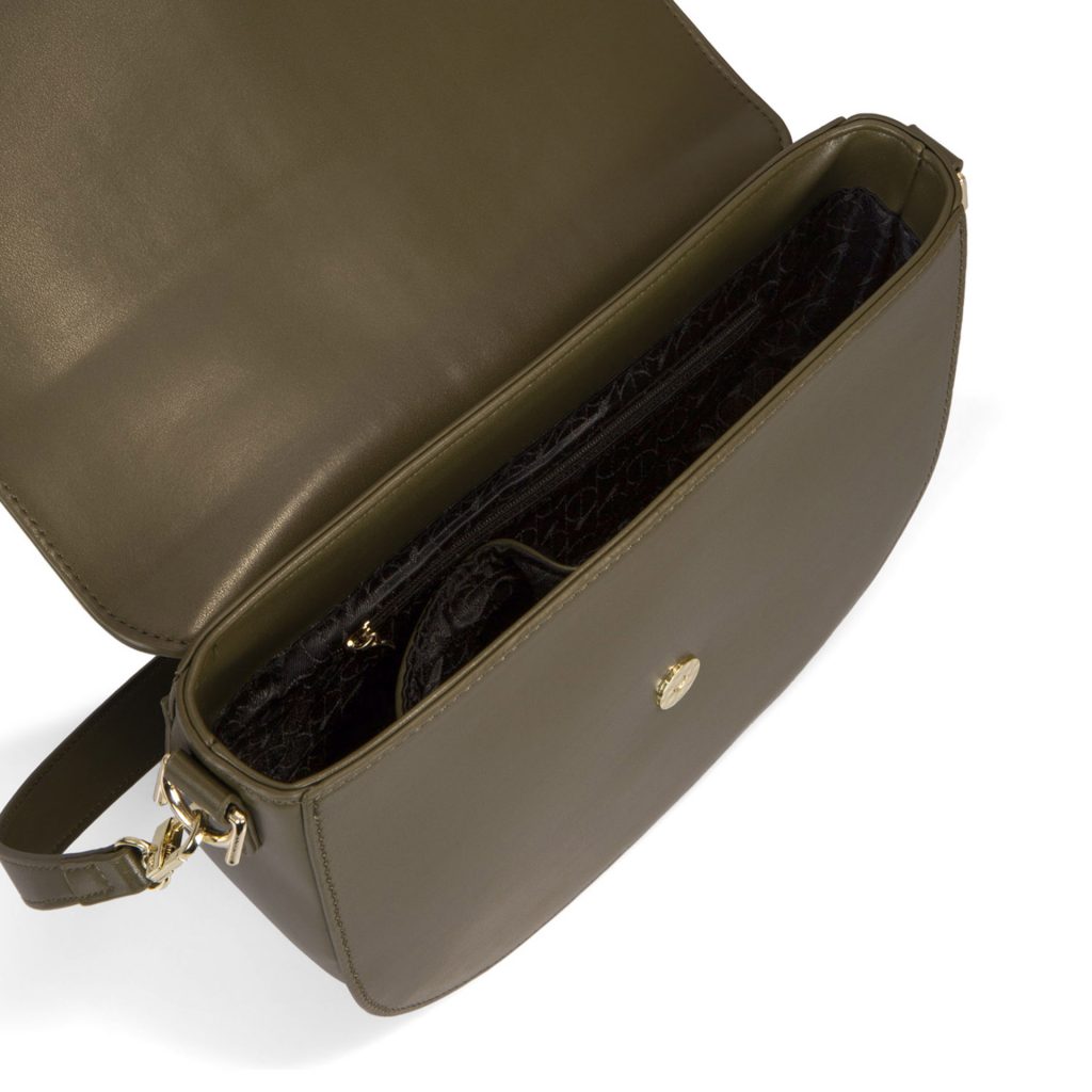 Overhead interior view of an olive green crossbody bag that is called Abbie designed by Riona showing its faux leather texture and brand monogram lined print.