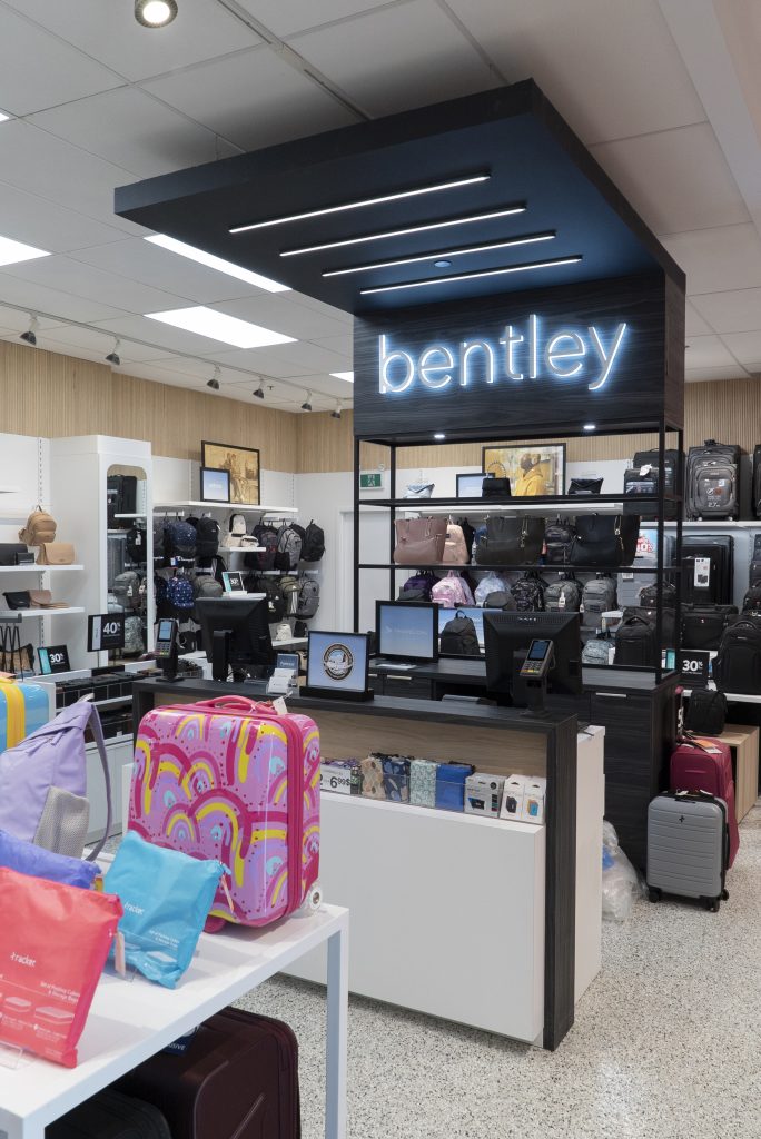 The check-out area at Bentley's concept store is illuminated, while displaying an assortment of travel gear. 