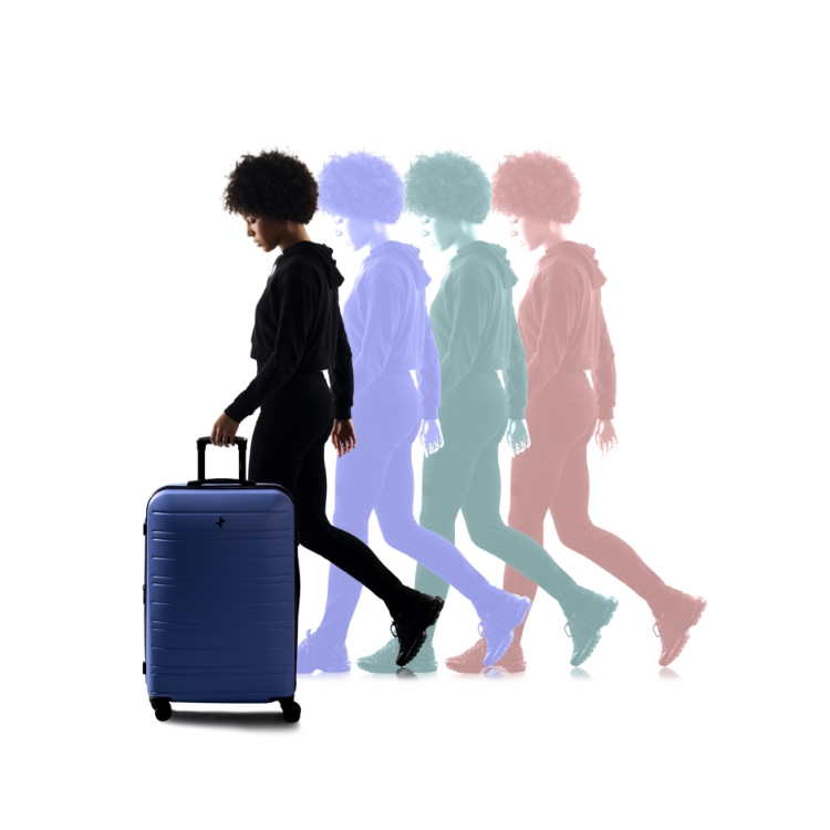 A woman who appears to be "evolving" holding a new Legend luggage from Tracker's the recent collection.